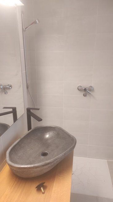 Un baño con lavabo, espejo y ducha.