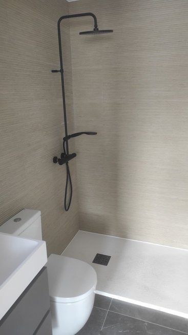 Un baño con inodoro, lavabo y ducha.