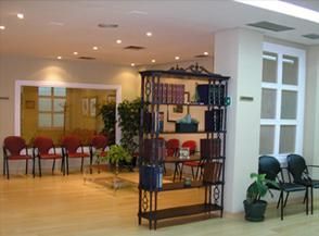 Una sala de espera con una estantería y sillas