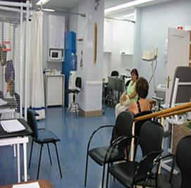 Una mujer está sentada en una silla en una sala de espera.