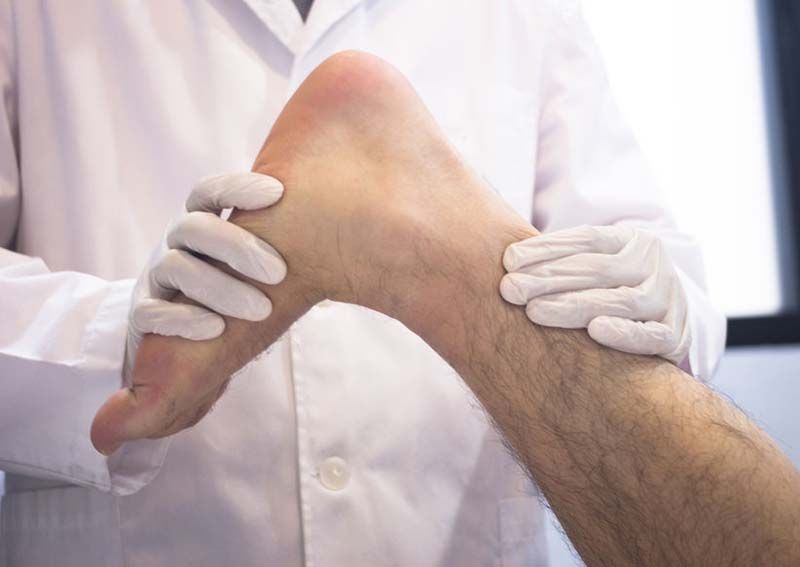 Un médico está examinando el pie de un paciente.