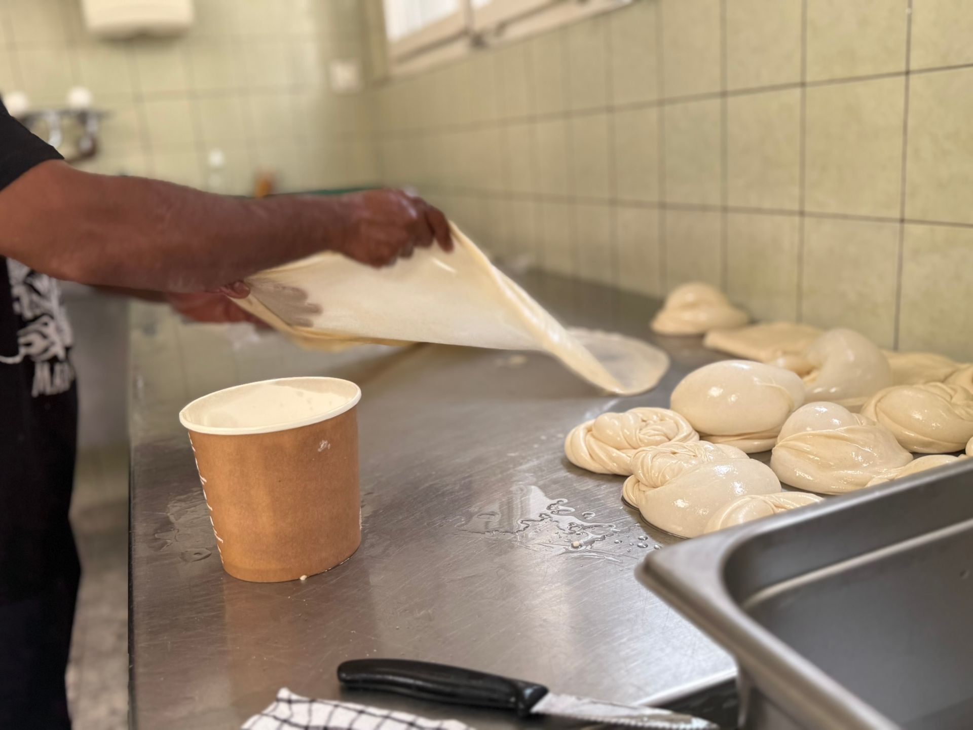Dünne, runde Dosa, die auf einer heißen, flachen Grillplatte gegart werden. Dampf steigt von den Rändern auf.