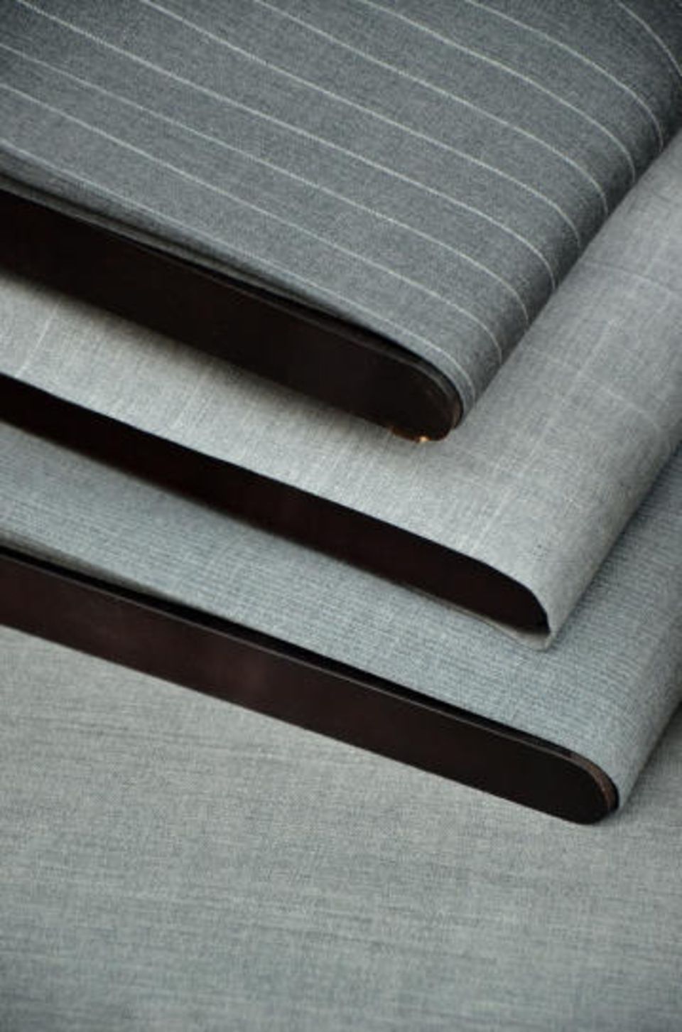 Drei Stücke grau gestreiften Stoffes sind übereinander gestapelt.