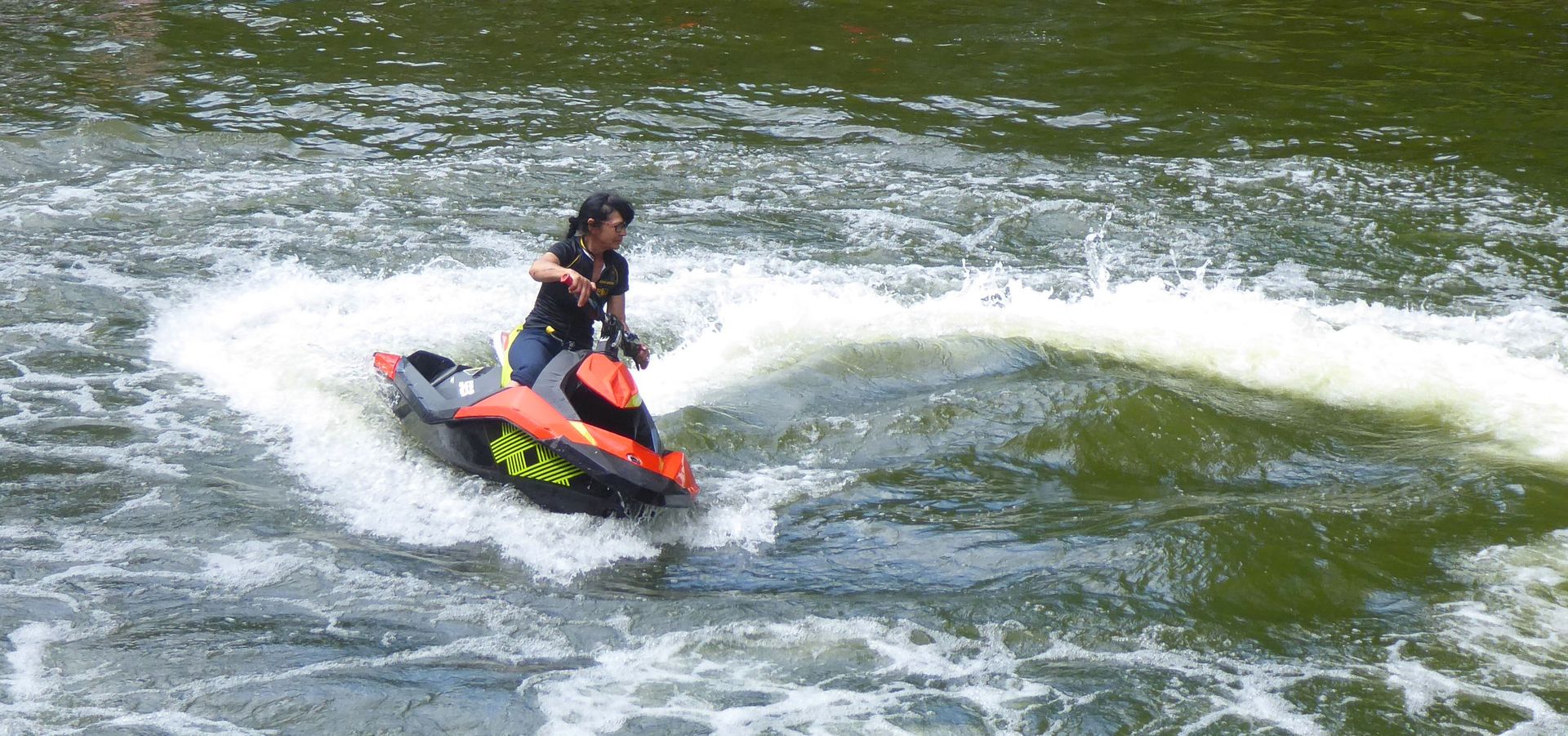 Eine Person fährt mit einem Jetski auf einem Fluss.