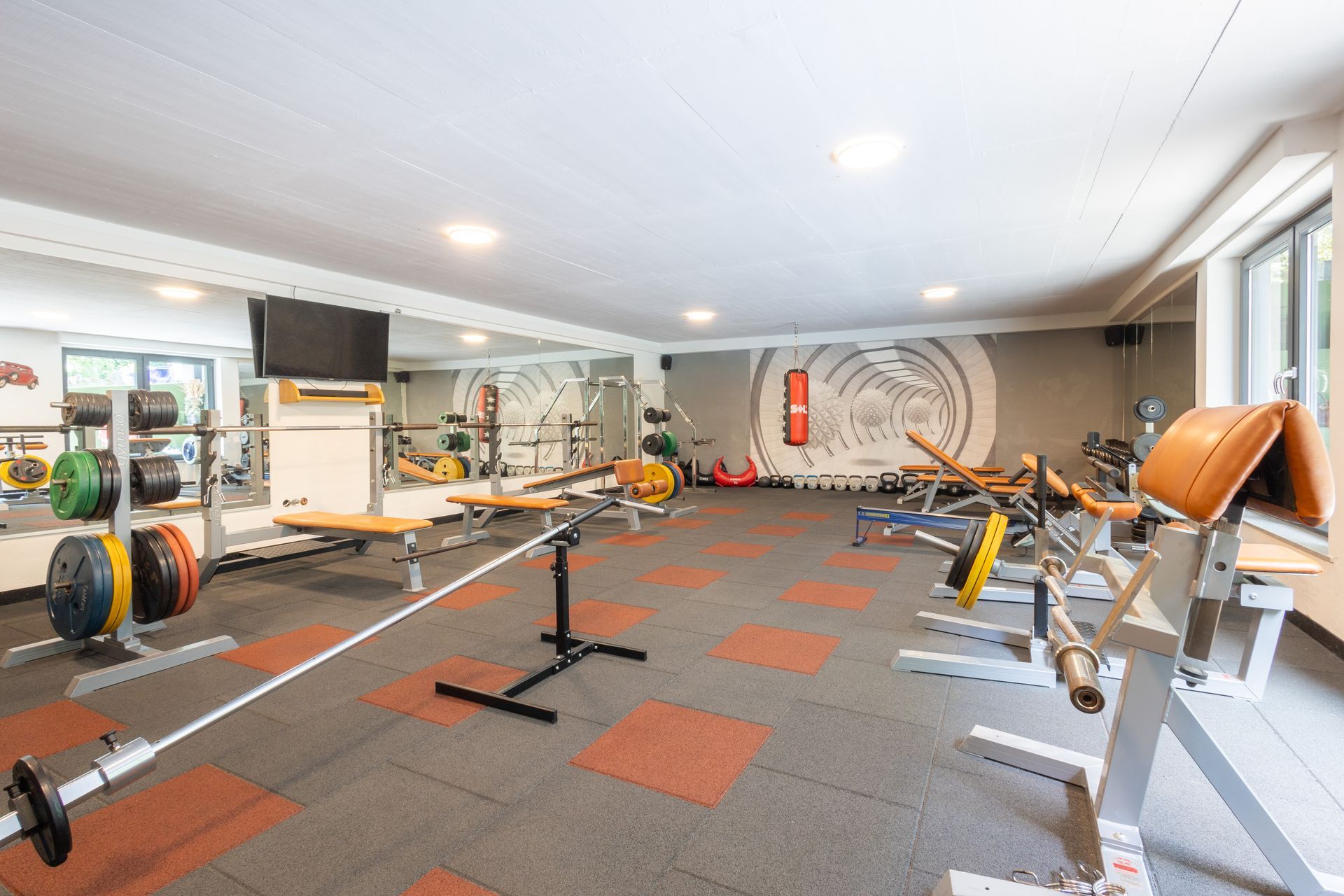 Ein großes Fitnessstudio mit einem Fernseher an der Wand