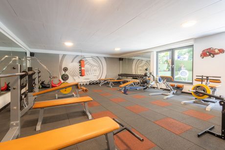 Ein Wohnzimmer voller Trainingsgeräte und einem Flachbildfernseher.