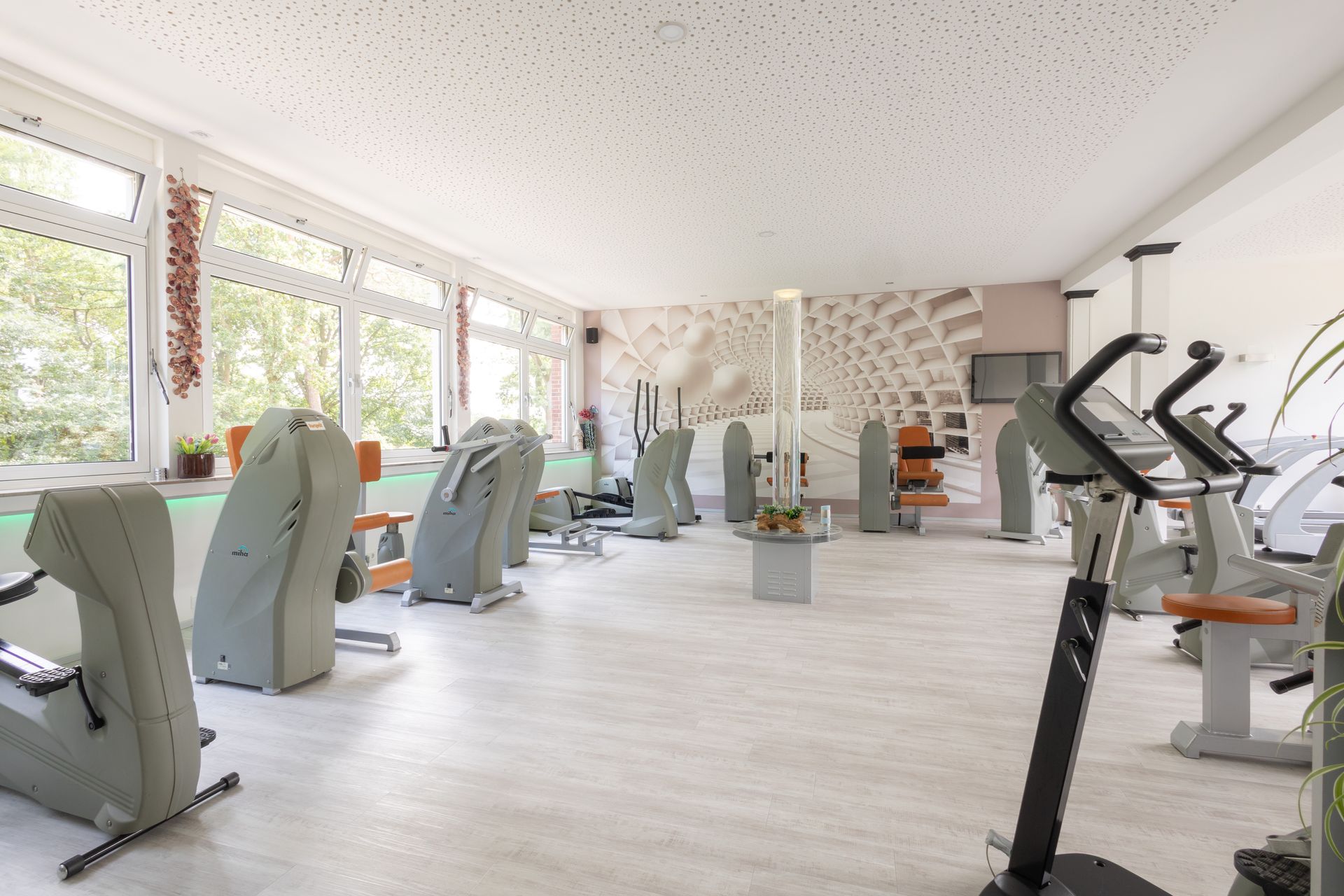 Ein Fitnessstudio mit vielen Trainingsgeräten und ein Swimmingpool.