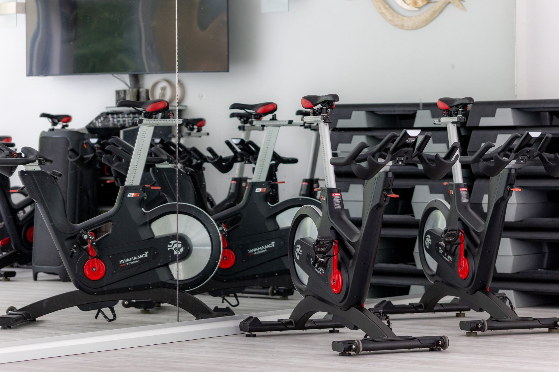 Ein Fitnessstudio mit vielen Trainingsgeräten und vielen Fenstern.