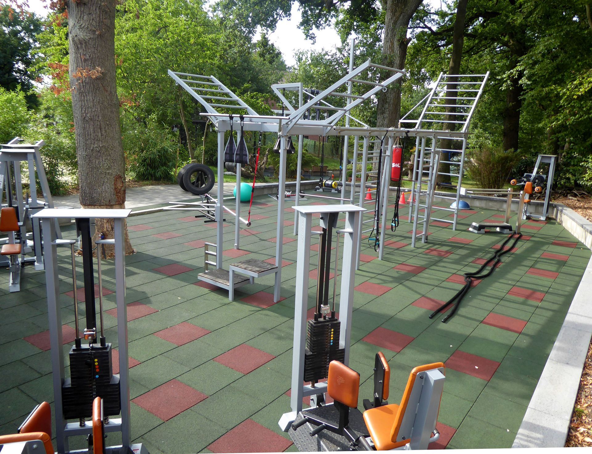 Eine Reihe von Trainingsgeräten in einem Park mit Bäumen im Hintergrund