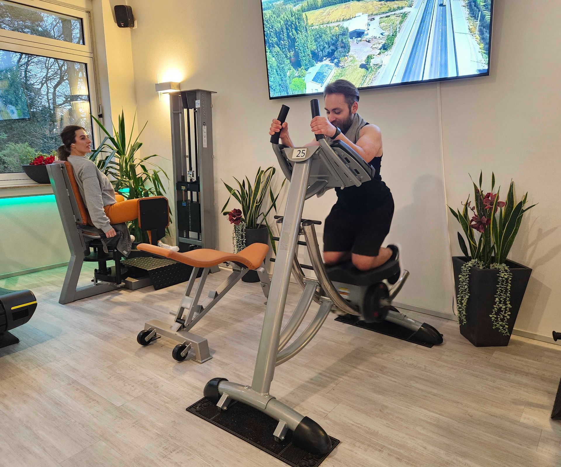 Ein Mann fährt in einem Fitnessstudio auf einem Heimtrainer.