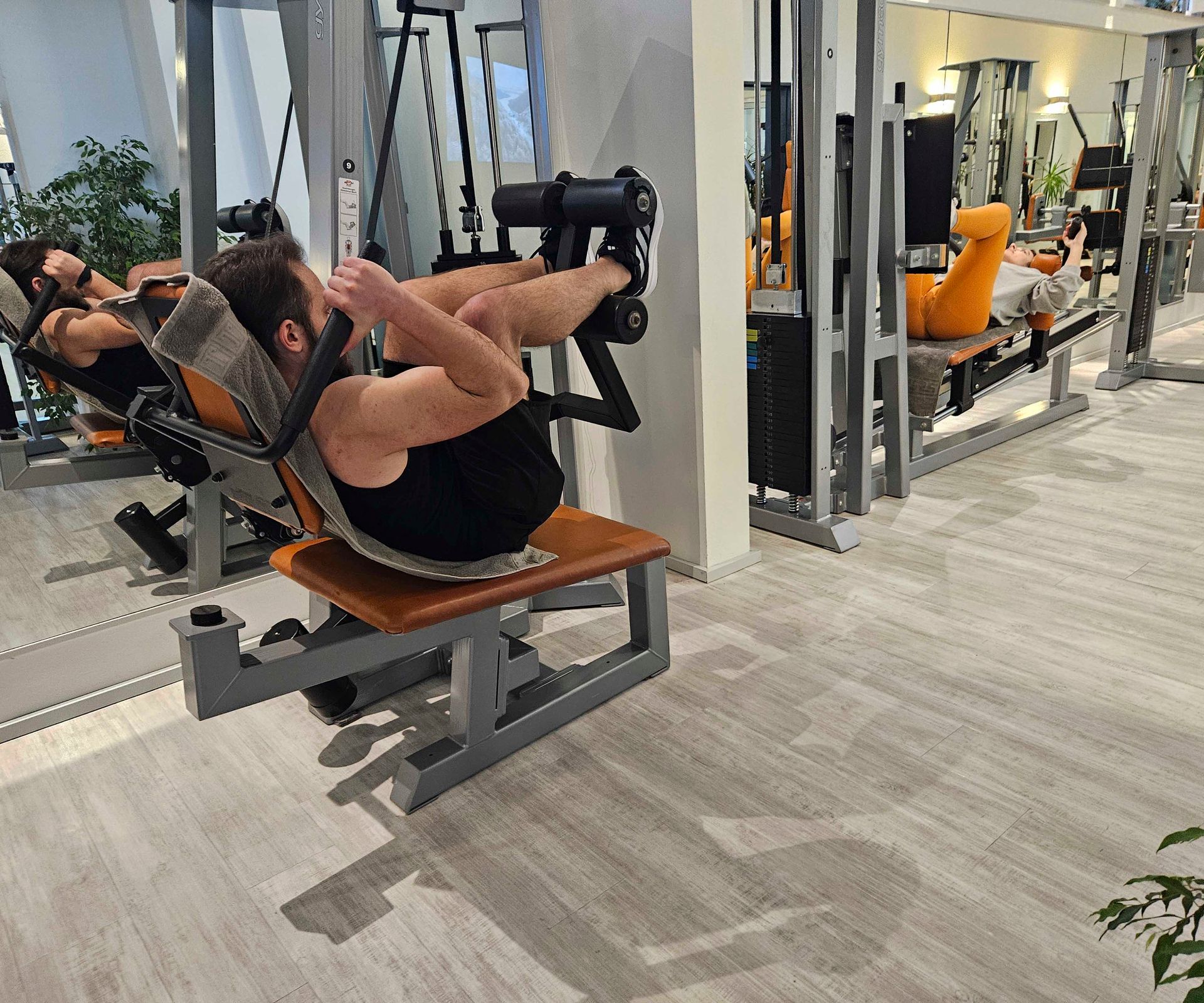 Ein Mann macht in einem Fitnessstudio Übungen an einem Gerät.