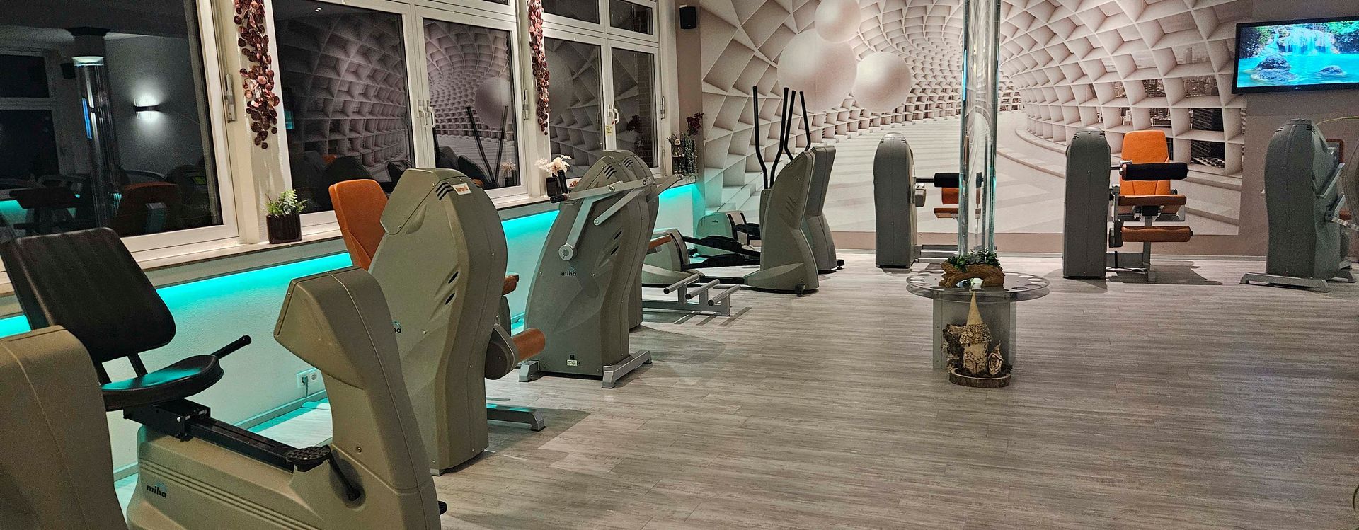 Ein Fitnessstudio mit vielen Trainingsgeräten und ein Swimmingpool.