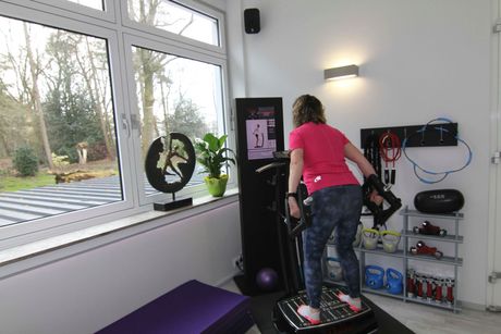Eine Frau steht auf einer Plattform in einem Fitnessstudio.