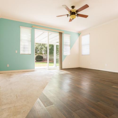 Chambre avec un mur bleu sarcelle, des murs beiges, un parquet et de la moquette, avec un ventilateur de plafond.