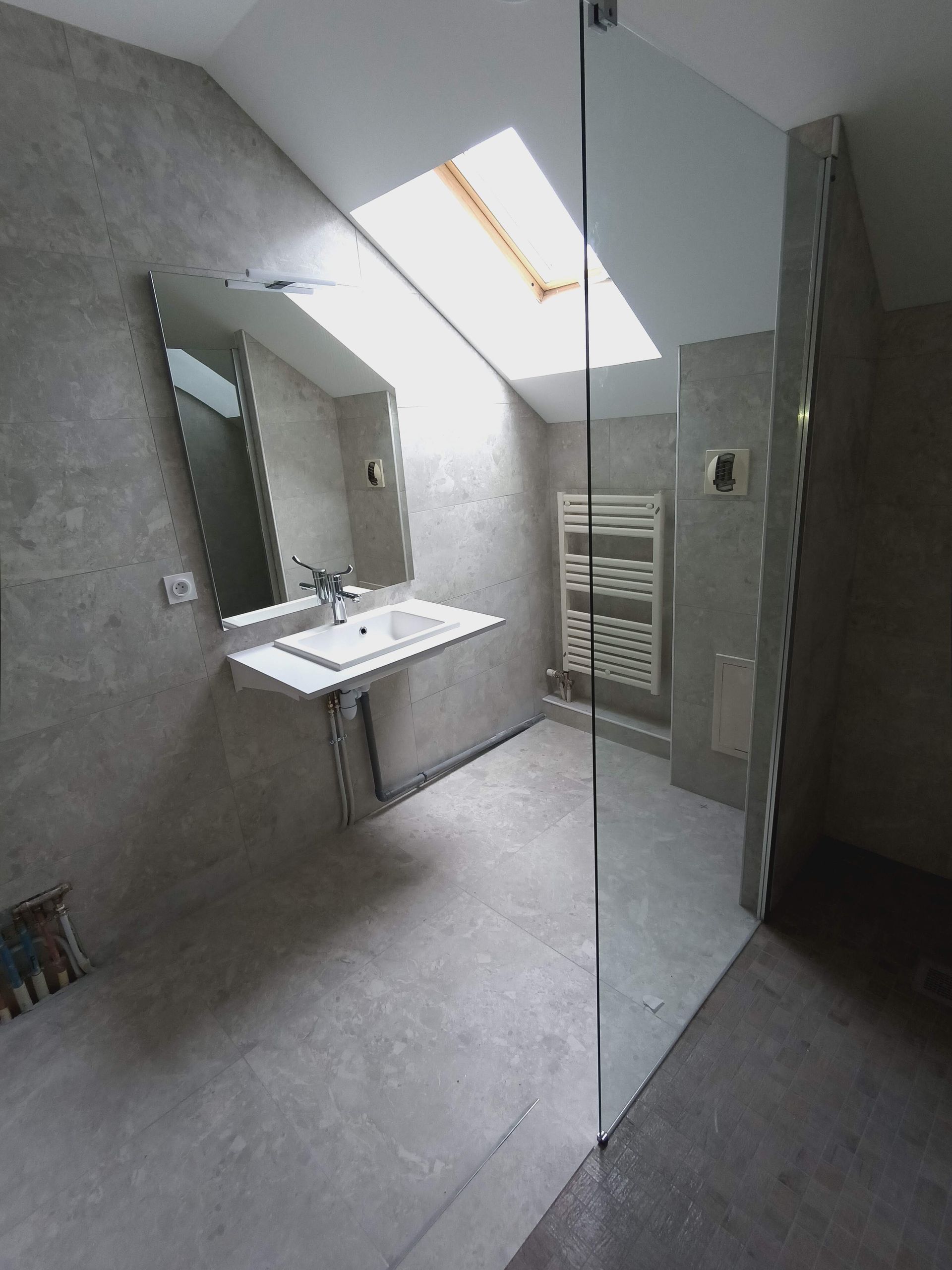 Un lavabo vu à travers une paroi en verre de douche