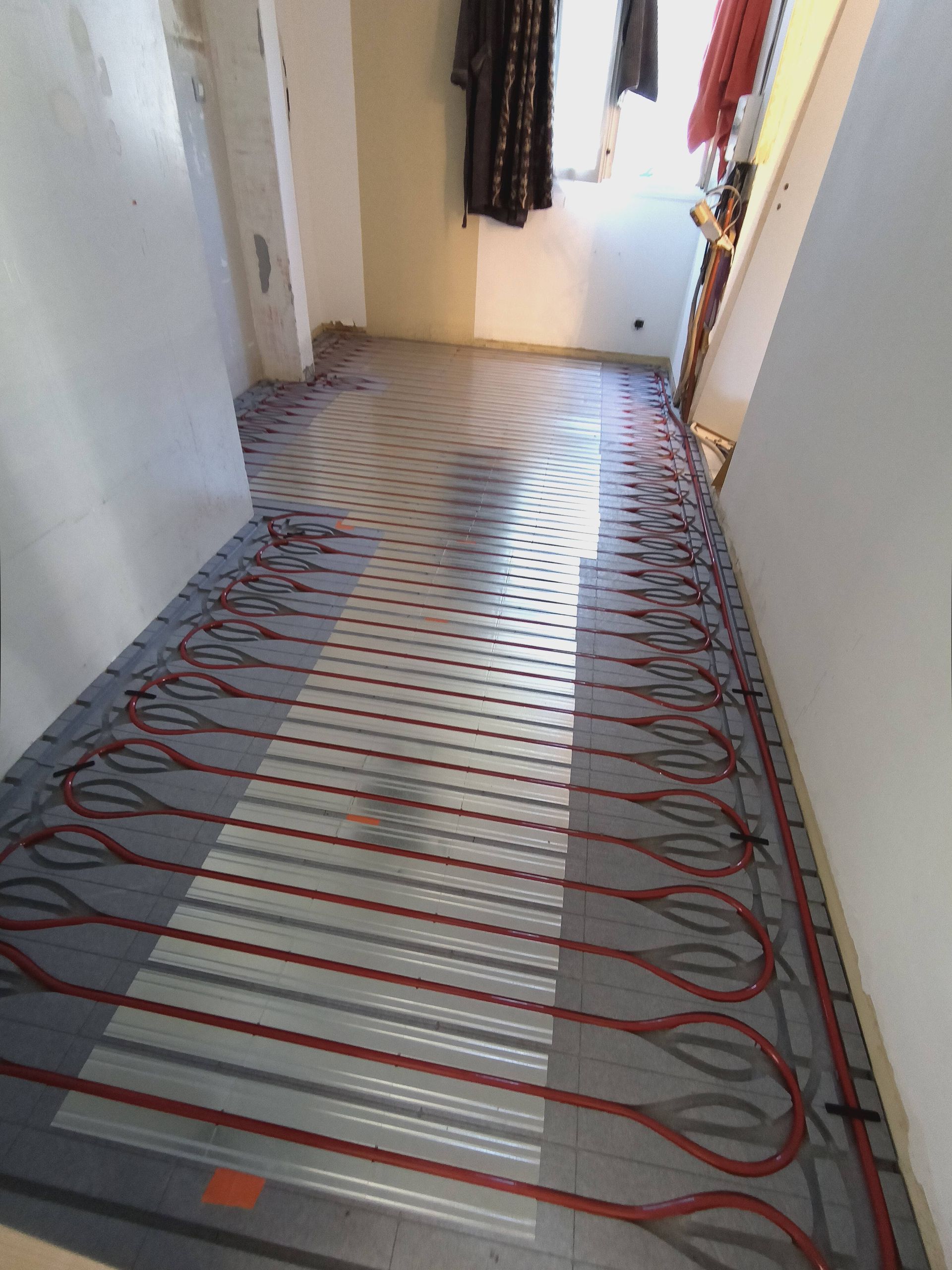 Un couloir avec des tuyaux par terre