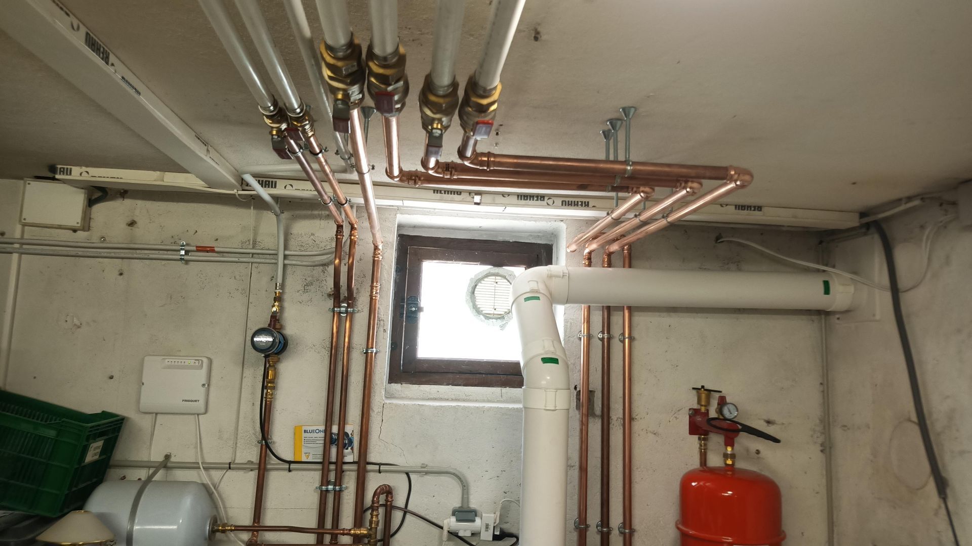 Des tuyaux installés au plafond d'une pièce en soubassement