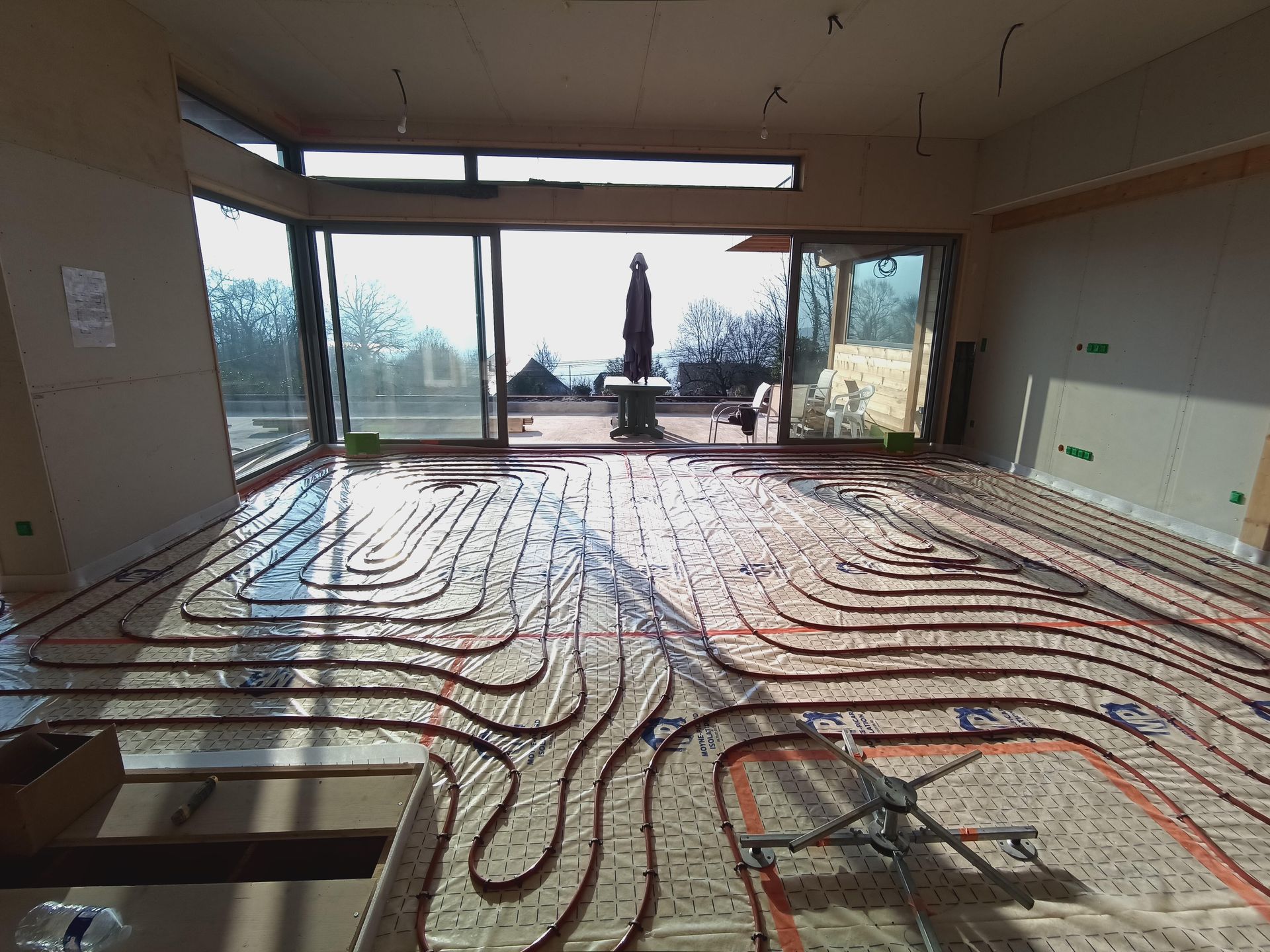 Une pièce avec des baies vitrées et un parasol plié dehors