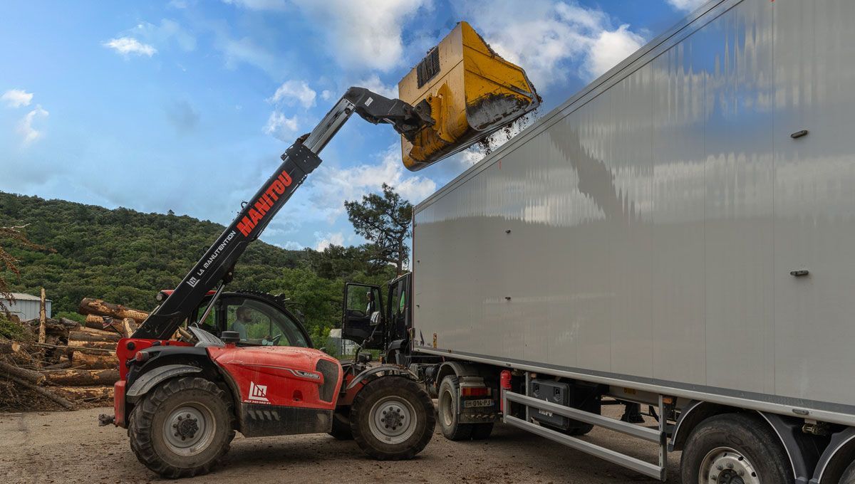 Manitou qui charge des résidus de bois dans un camion