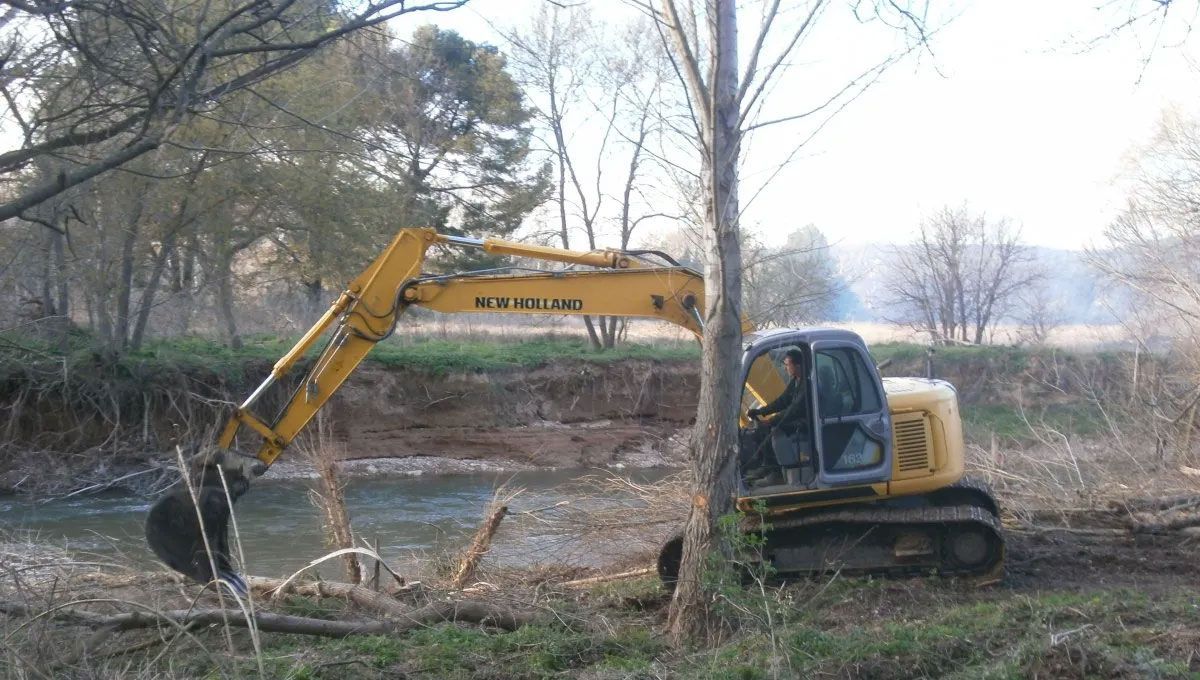 Pelleteuse qui enlève des déchets dans une rivière