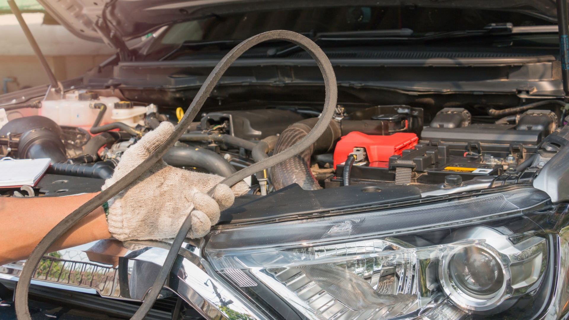 Le mécanicien tient une courroie de distribution dans la main.