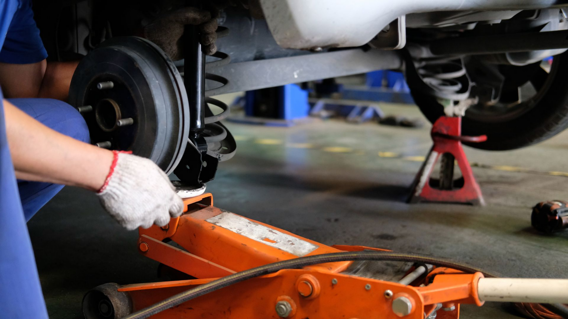 Un mécanicien remplace l'amortisseur d'une voiture.