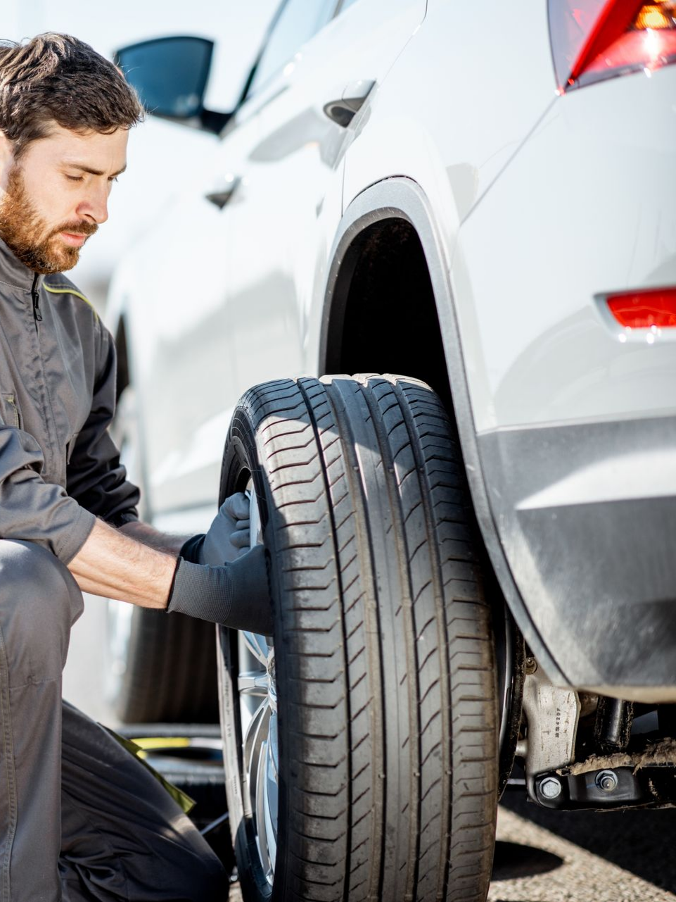 Un dépanneur change une roue de voiture.