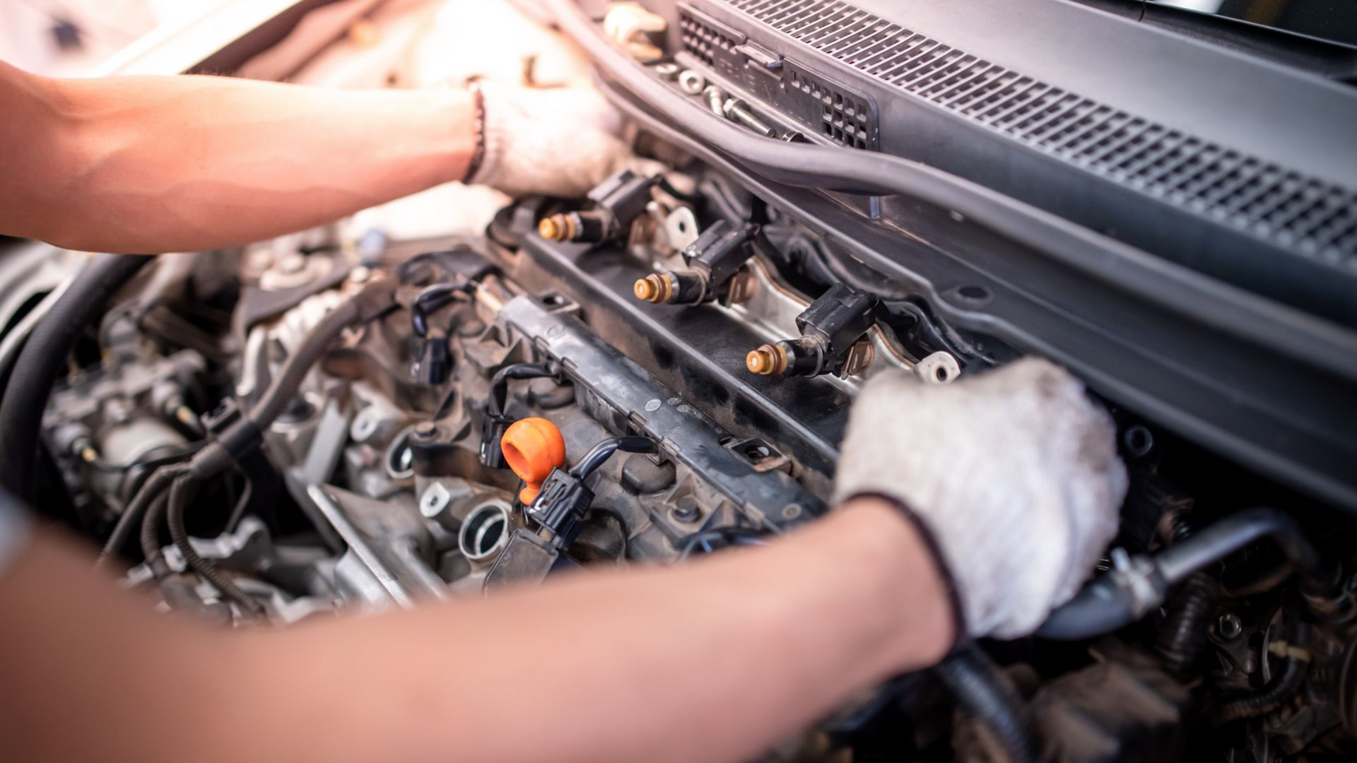 Le technicien remplace les injecteurs d'une voiture.