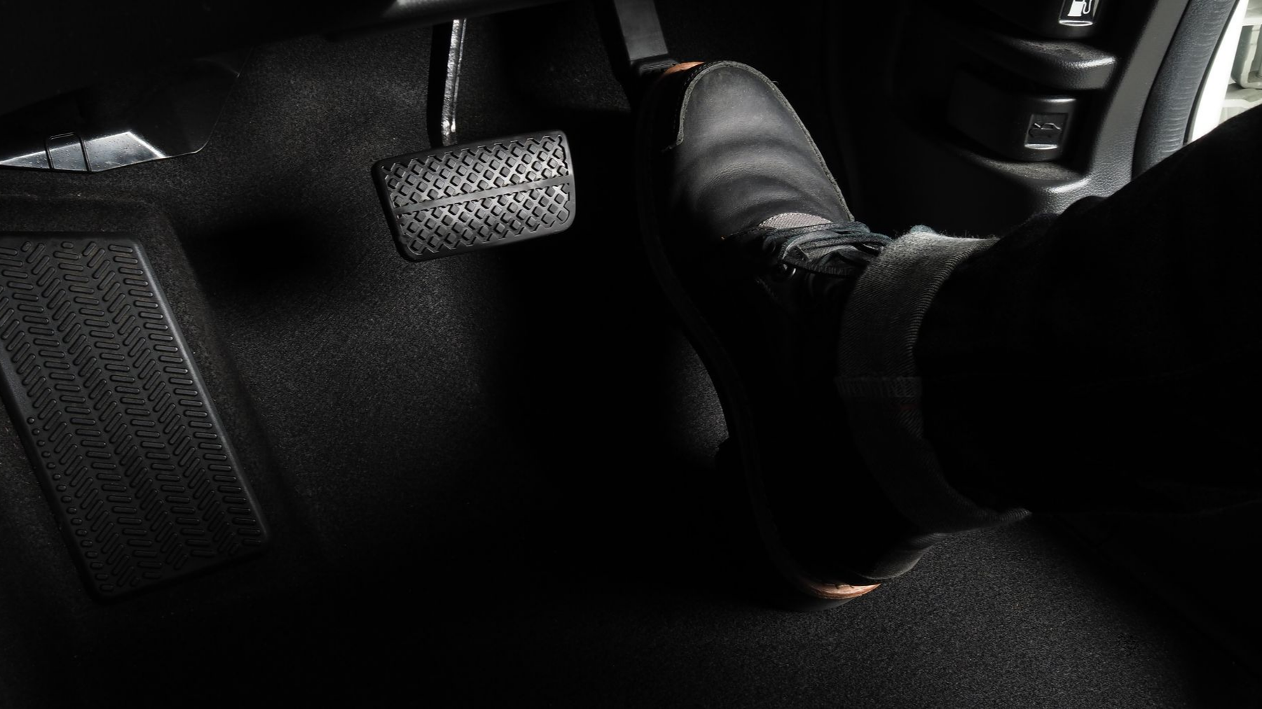 Un pied posé sur la pédale d'un véhicule.