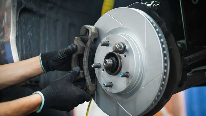 Le garagiste remplace une plaquette de frein.