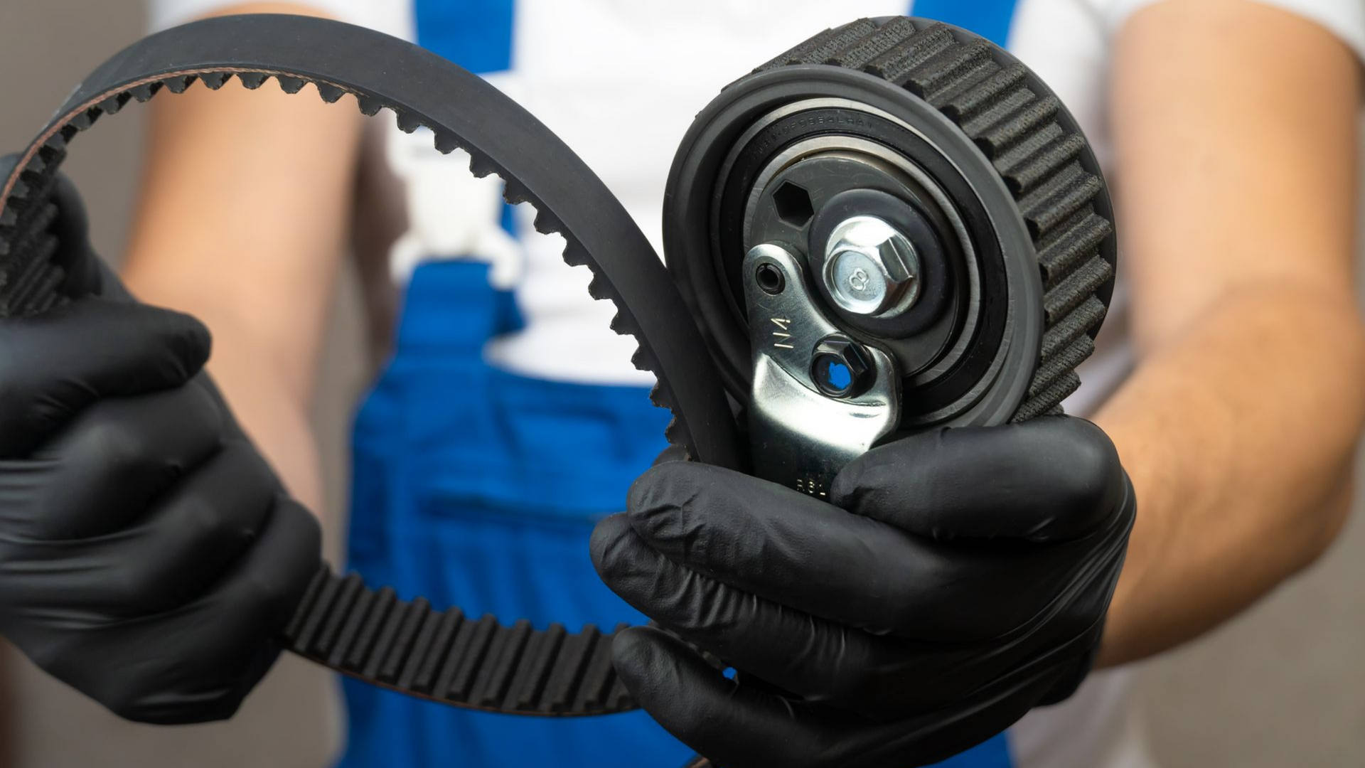 Mécanicien tenant dans ses mains une nouvelle courroie de distribution