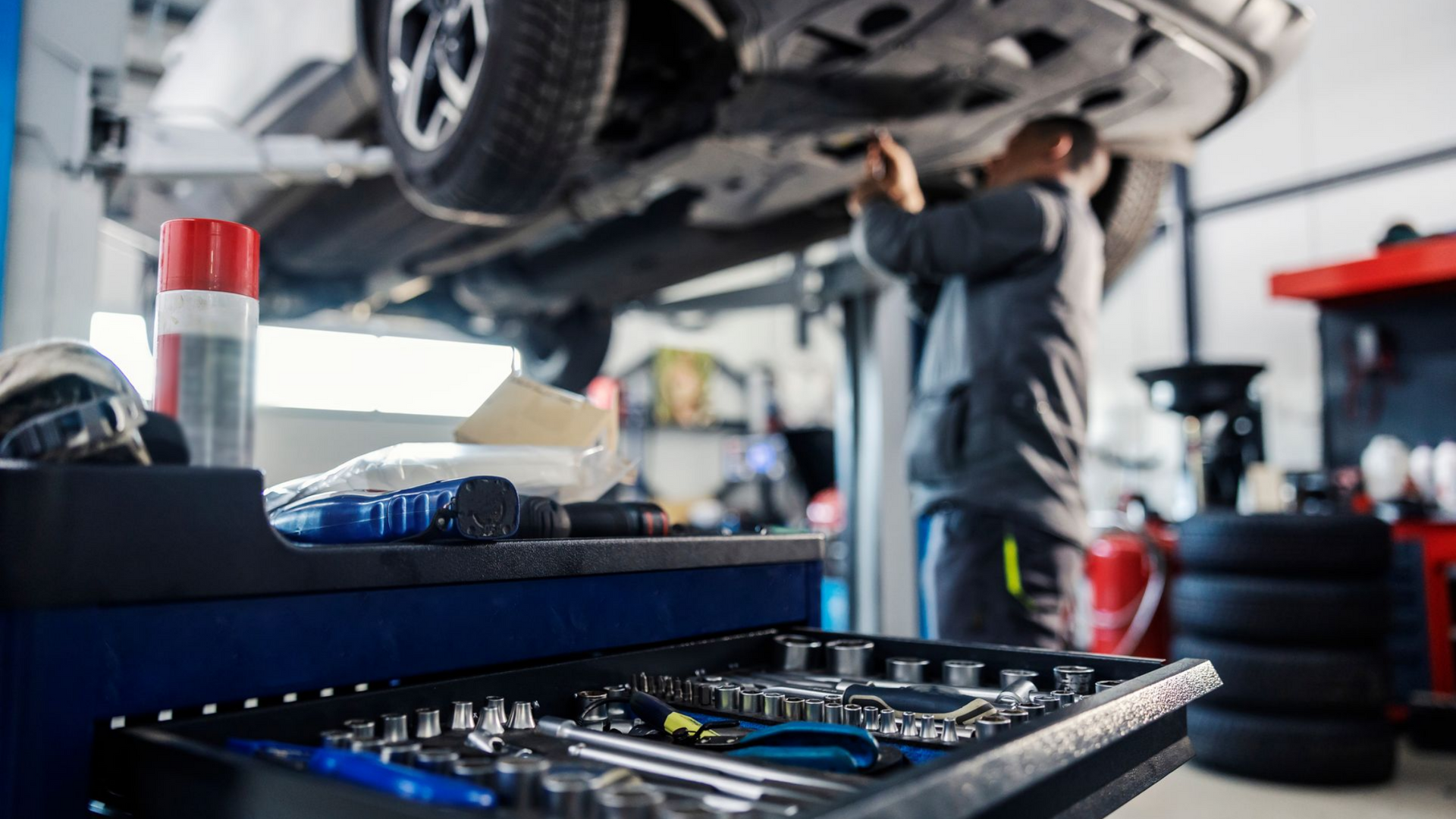Le garagiste travaille sous un véhicule monté sur un pont.