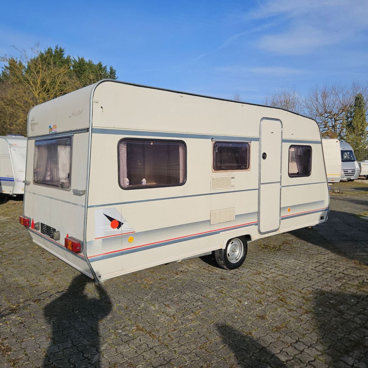 Caravane beige garée à l'extérieur.