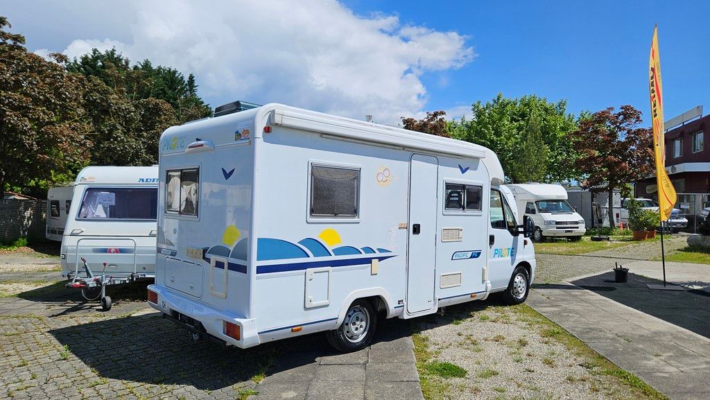 Un camping-car blanc est garé sur un parking.