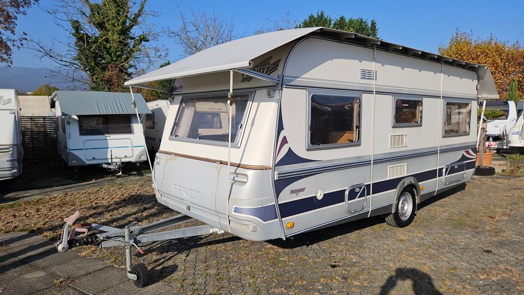 Une remorque avec un auvent dessus est garée sur un parking.