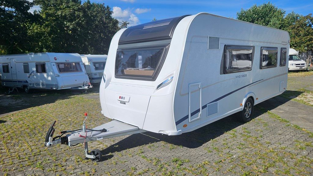 Une caravane blanche est garée sur un parking.