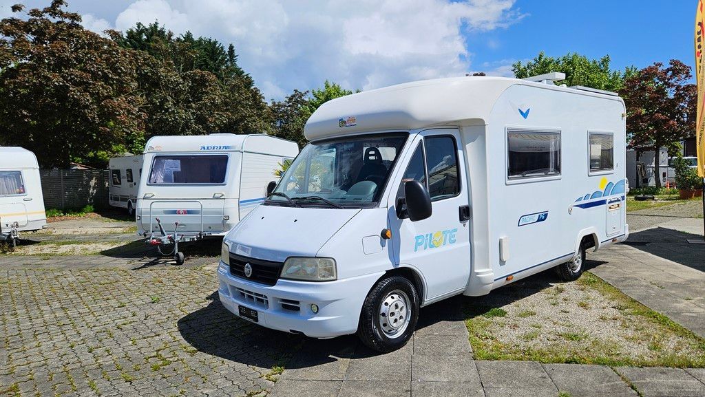 Un camping-car blanc est garé sur un parking.