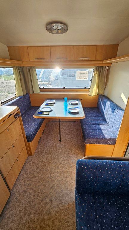 L'intérieur d'un camping-car avec une table et des chaises.