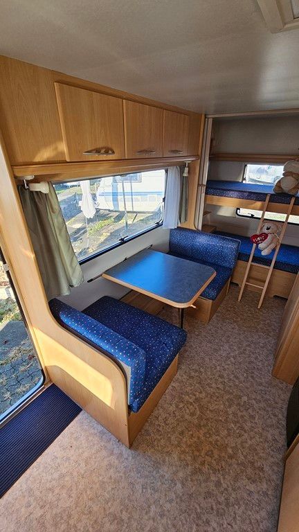 L'intérieur d'un camping-car avec des lits superposés et une table.