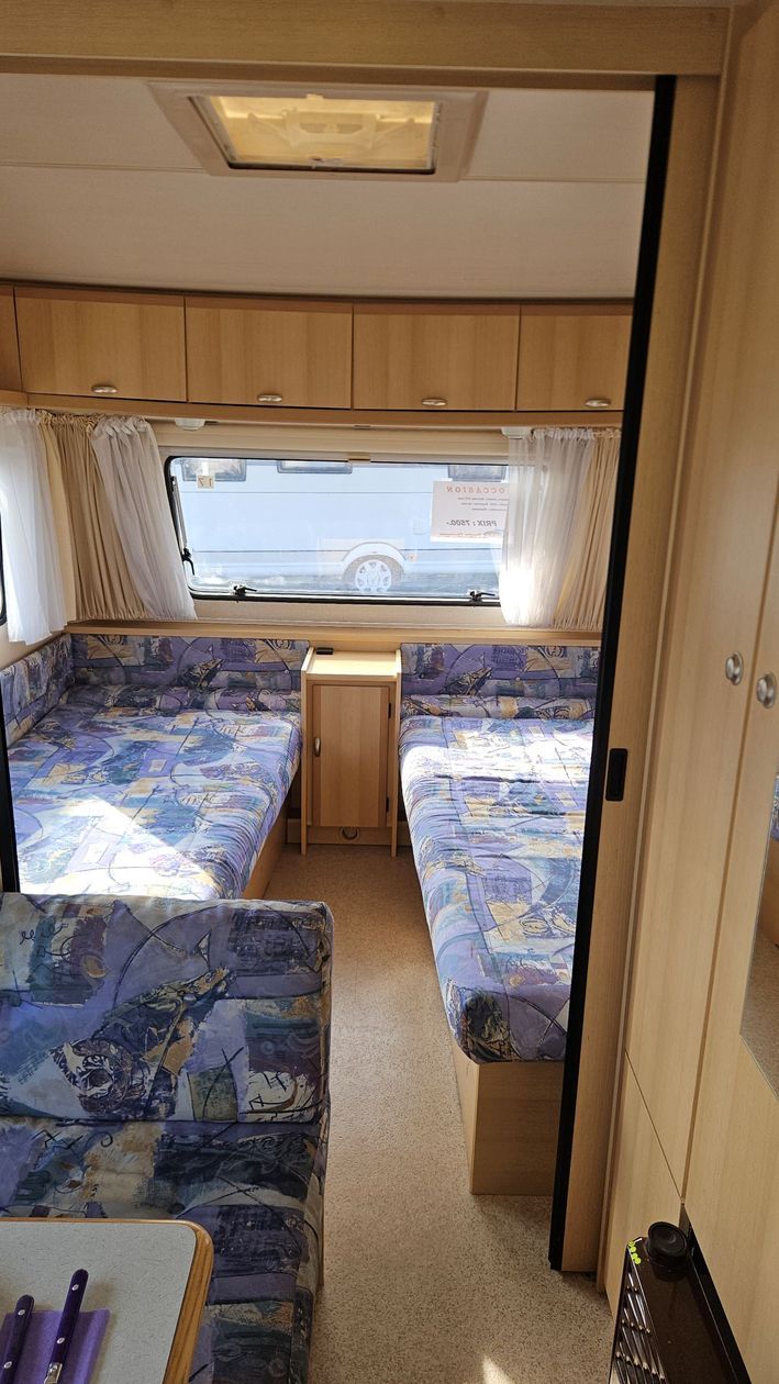 L'intérieur d'un camping-car avec deux lits et une table.