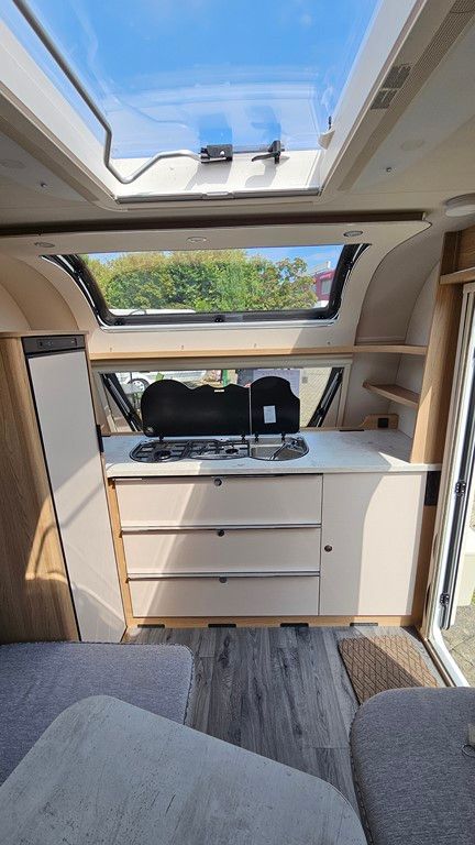 L'intérieur d'une caravane avec une lucarne et un four à cuisinière.