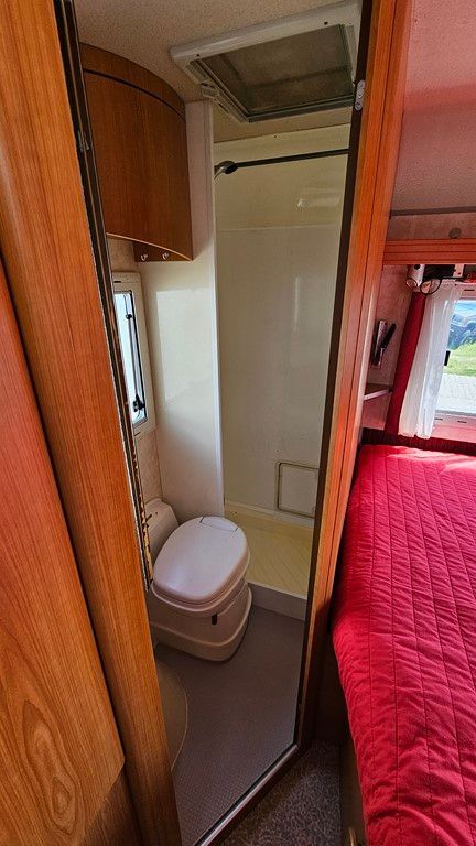 Une salle de bain dans un camping-car avec WC et douche.