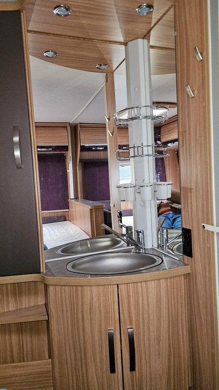 Une salle de bain dans un camping-car avec un lavabo et un miroir.