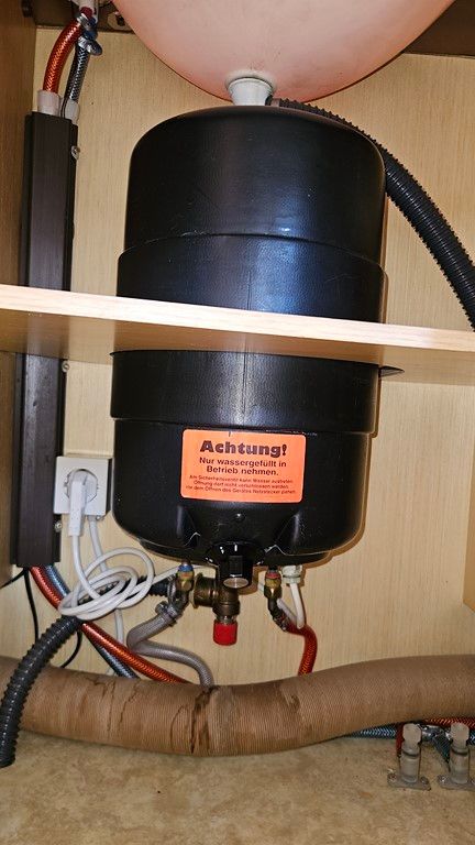 Un récipient noir avec une étiquette orange sur laquelle est écrit « achtung »