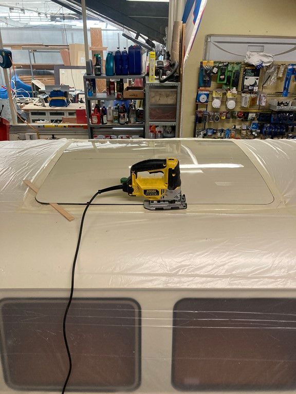 Une scie jaune est posée sur un toit blanc.