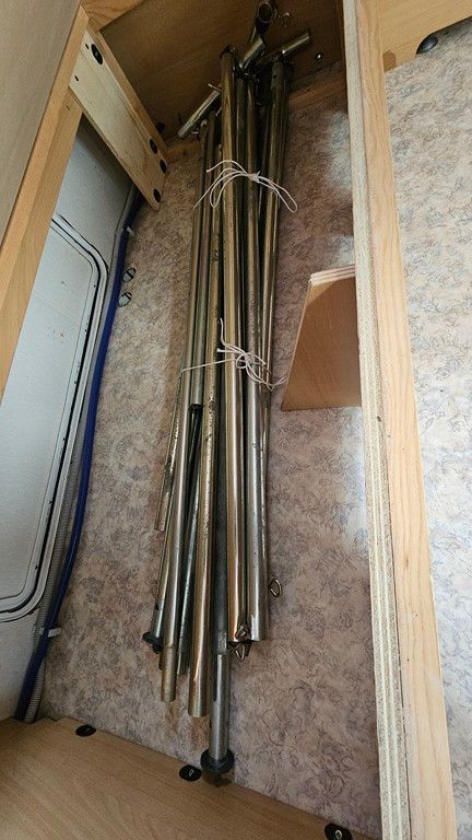 Un tas de poteaux métalliques sont empilés les uns sur les autres dans une pièce.