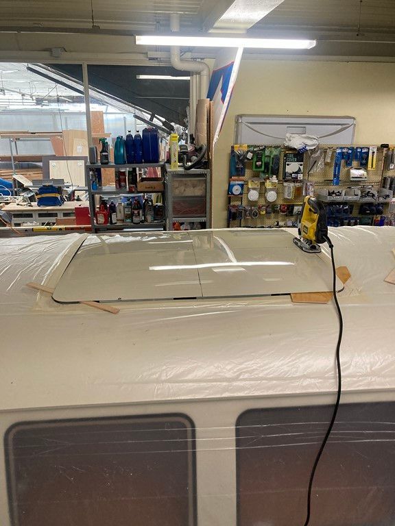 Un toit avec un trou est en cours de réparation dans un garage.