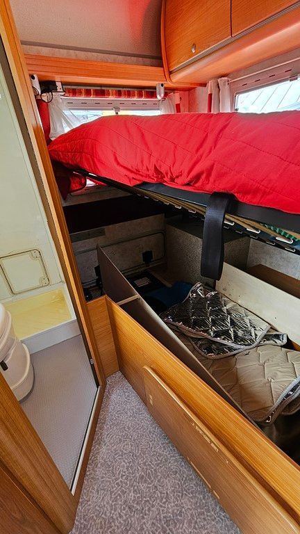 Il y a un lit à l'arrière d'un camping-car.