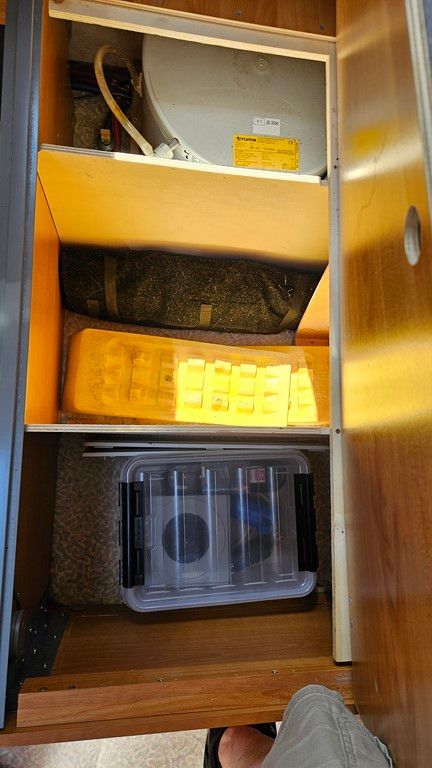 Une personne se tient à côté d'un tiroir avec des toilettes à l'intérieur.