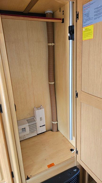 Une armoire en bois avec un tuyau qui en sort.